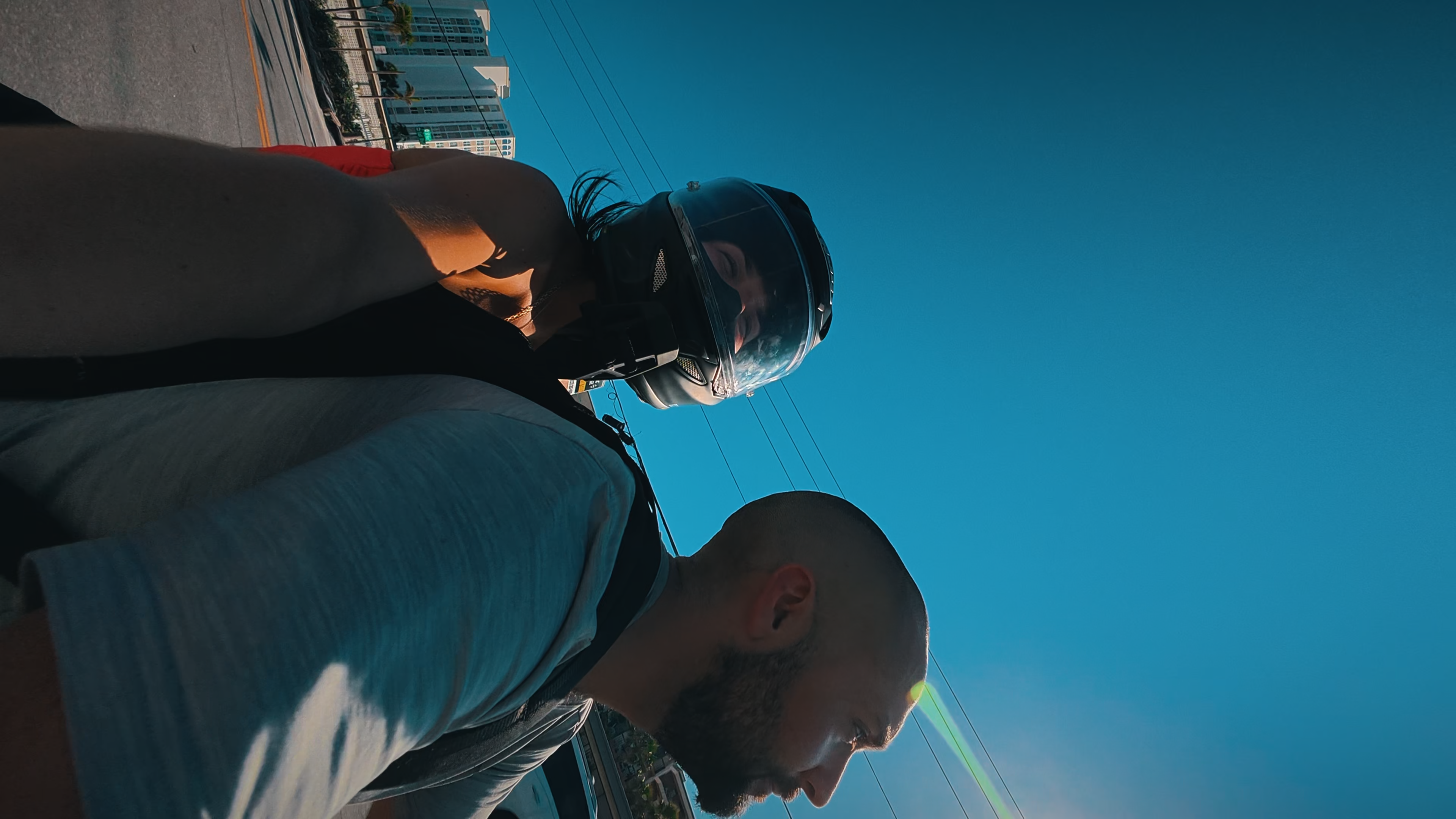 Ryan wearing a motorcycle helmet beneath a blue sky.