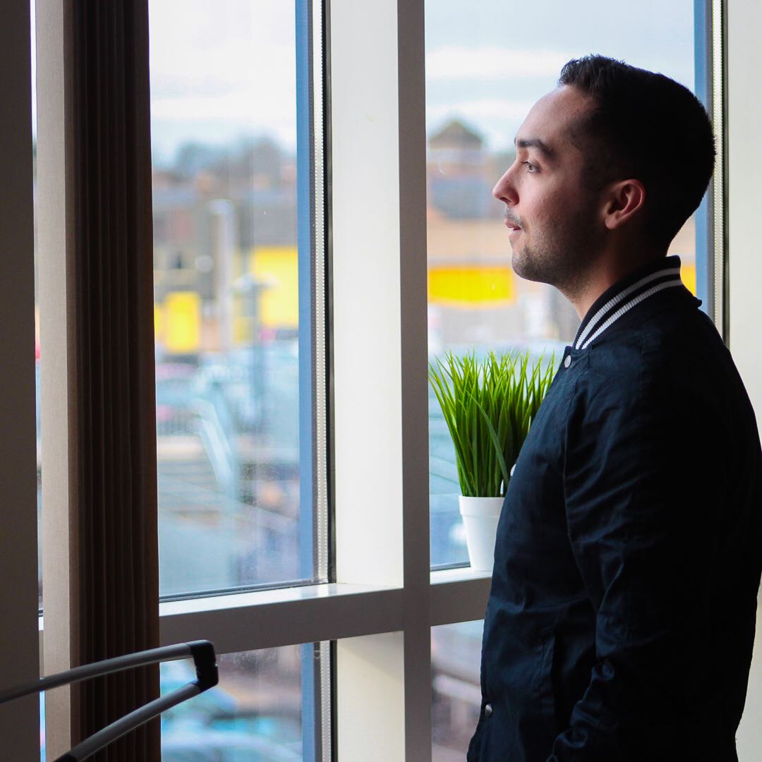 Ryan Chang in profile beside a window.